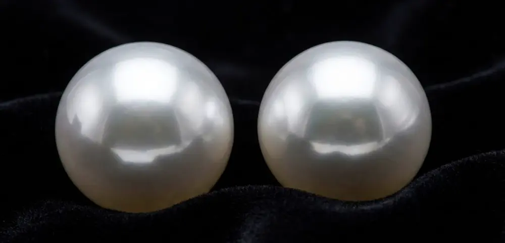 Edison Pearls vs South Sea Pearls: Why Designers Are Choosing the Affordable Alternative 1 Side-by-side comparison of Edison pearls vs South Sea pearls showing identical high luster and size on black background.